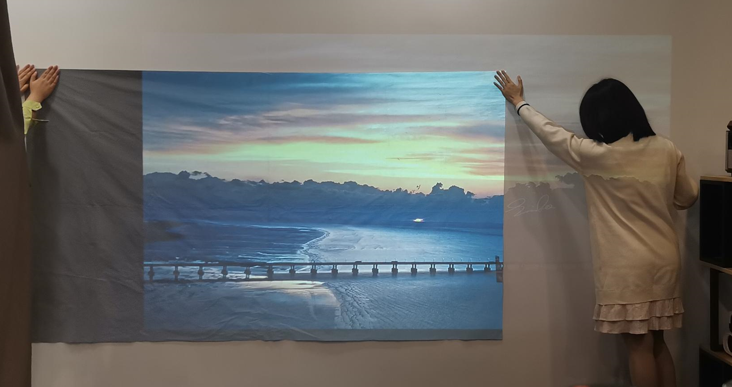 Foldable projector screen mounted on wall